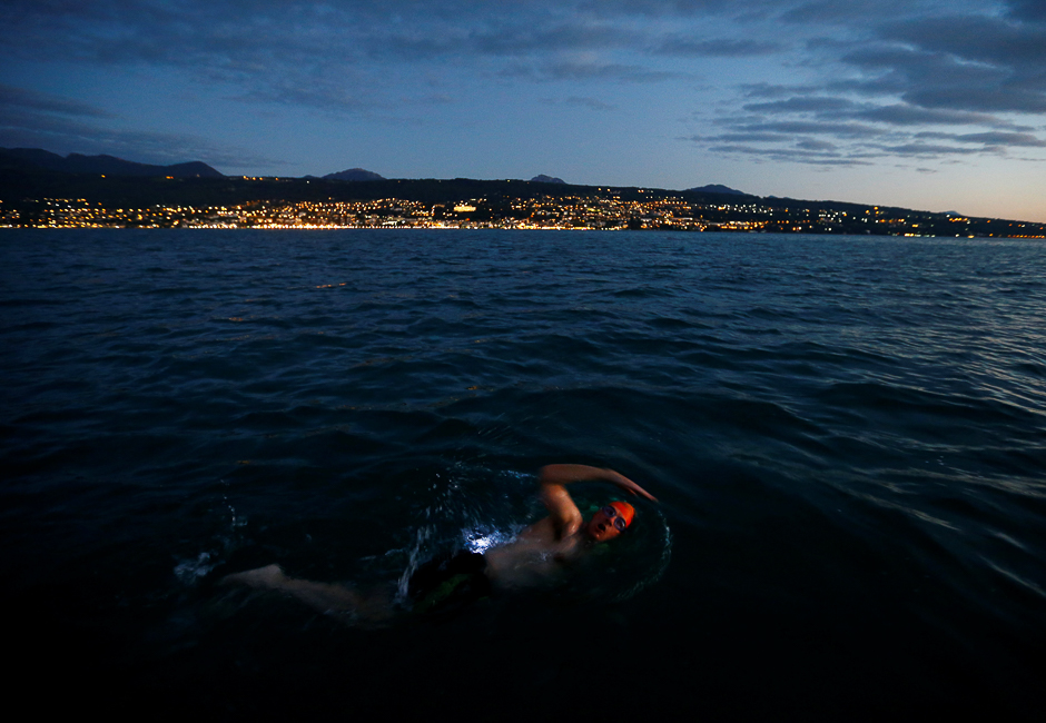 Peter Whitehead swims at sunset during a 70 km relay across Lake Leman from Montreux to Geneva, near Evian-les-Bains, France, near Switzerland. PHOTO: REUTERS