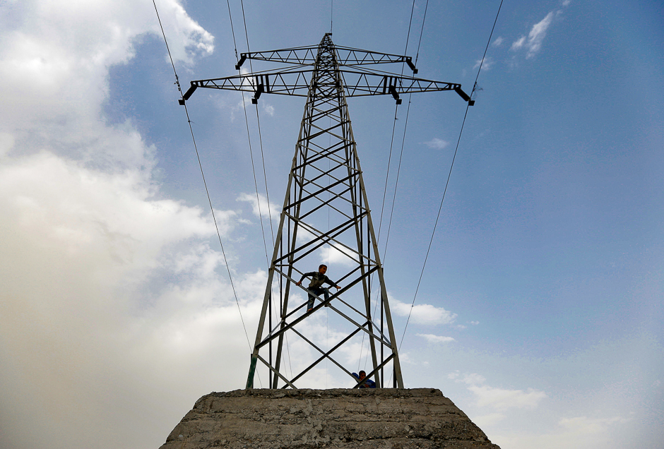 An Afghan boy plays on an electricity pylon in Kabul, Afghanistan. PHOTO: REUTERS