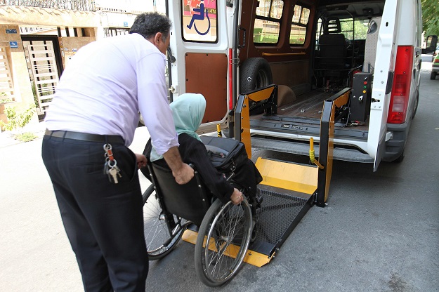 Iranian Fatemeh Nikbakht, who lost the use of her legs in an accident in the 1990s and today runs the Spinal Cord Injury Association, sits on her wheelchair as she boards a disability bus service on August 1, 2017 in Tehran. PHOTO: AFP