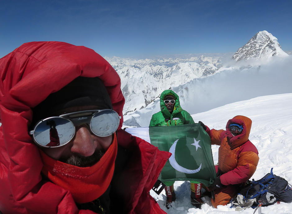 Veteran alpinist Oscar Cadiach (C) along with members of his team as they hoist the Pakistani flag on top of the 8,051-metre high Broad Peak in northern Pakistan's Gilgit-Baltistan region. PHOTO: AFP