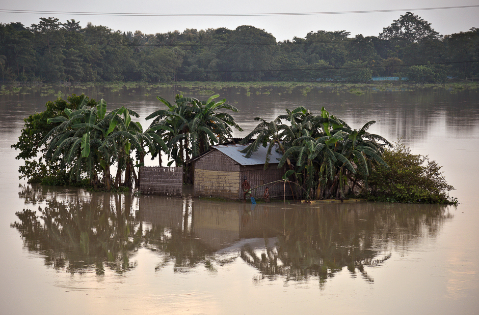 A man casts his fishing net in the flood waters next to his partially submerged hut in Morigaon district in the northeastern state of Assam, India. PHOTO: REUTERS