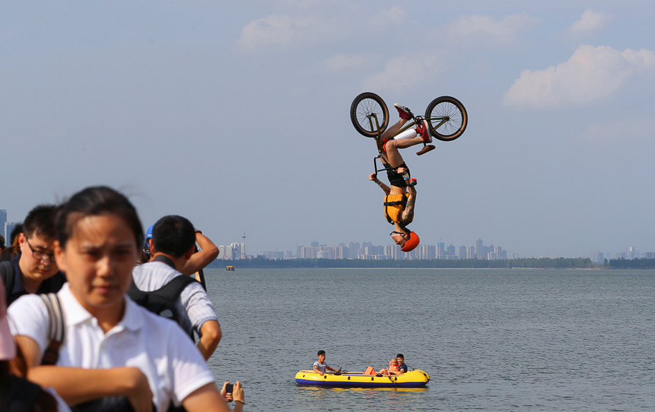 A man performs a BMX bicycle trick as he jumps into East Lake in Wuhan, Hubei Province, China. PHOTO: REUTERS