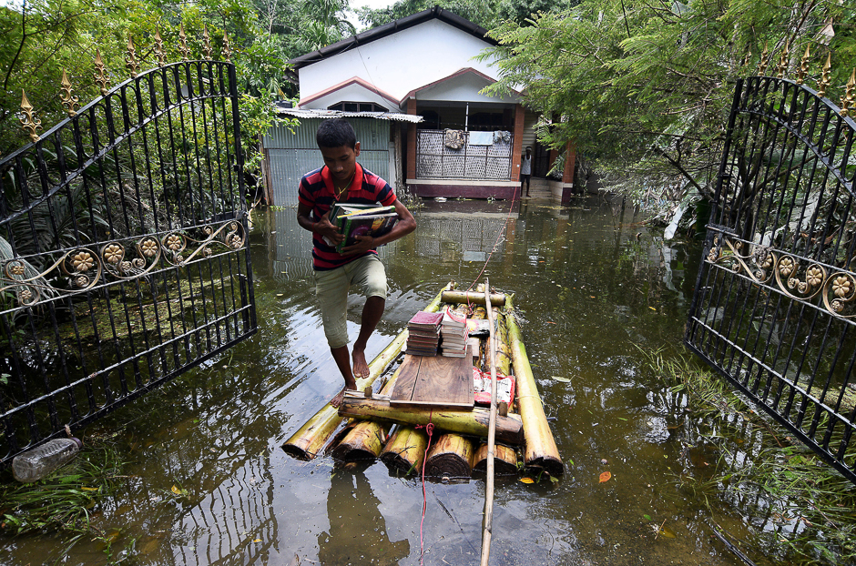 A boy uses a banana raft to transport his books in Jakhalabandha area in Nagaon district, in the northeastern state of Assam, India. PHOTO: REUTERS