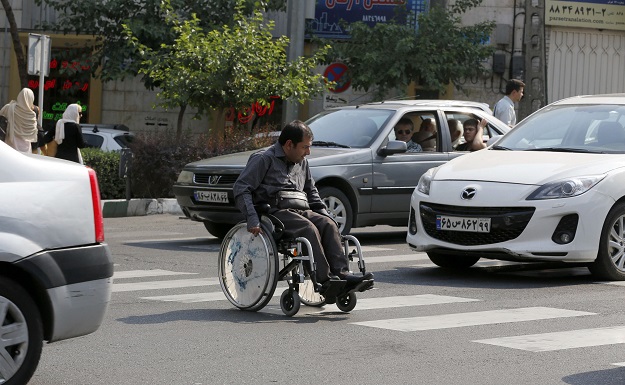 Behnam Soleimani, a 34-year-old Iranian computer teacher who uses a wheelchair, crosses a street in Tehran. PHOTO: AFP