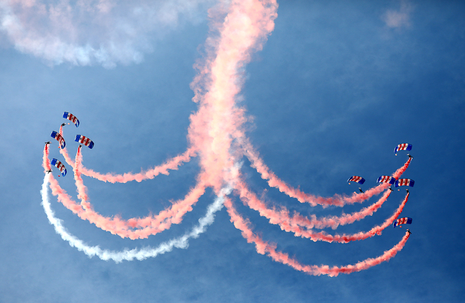 An RAF parachute display team let off smoke canisters as they descend as part of a ceremony for the Queen's Baton Relay for the 2018 Gold Coast Commonwealth Games at Brize Norton, Britain. PHOTO: REUTERS