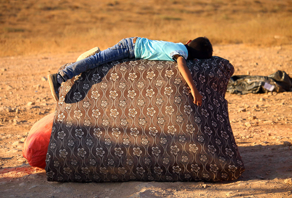 A Syrian refugee boy rests on the side of the road as he returns to Syria with his family in the southern province of Daraa. PHOTO: AFP