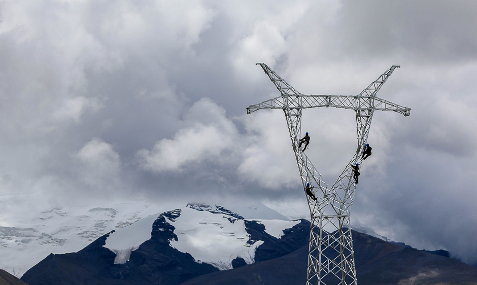 Technicians work on an electricity pylon in the mountains near Mengda village in Shannan Prefecture, Tibet Autonomous Region, China. PHOTO: REUTERS