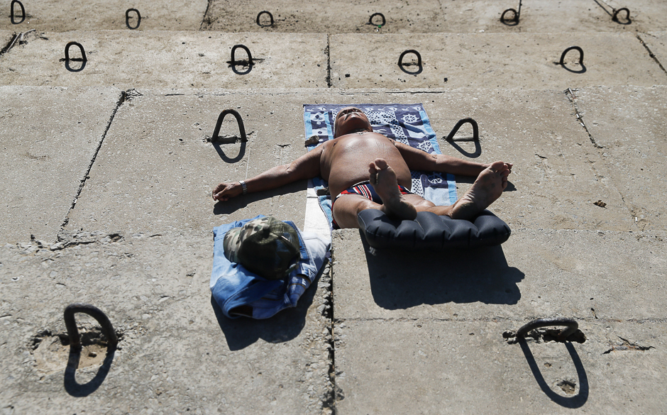 A man sunbathes on concrete slabs in the city of Volgograd, Russia. PHOTO: REUTERS