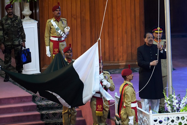 Pakistan's President Mamnoon Hussain (R) hoists national flag during a ceremony to mark the Independence Day in Islamabad on August 14, 2017. PHOTO: AFP