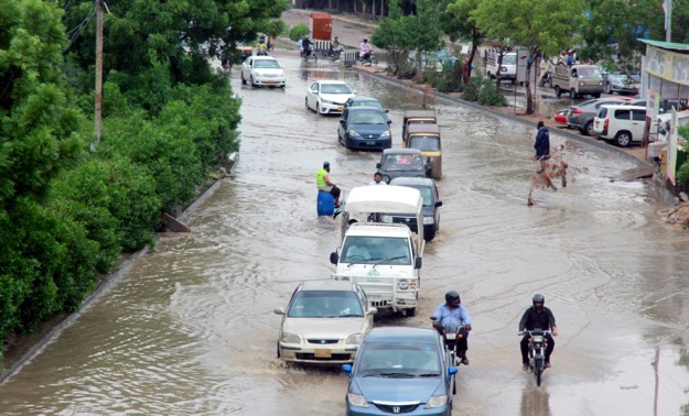 Cars navigate their way through water collected on the streets of Karachi. PHOTO: EXPRESS