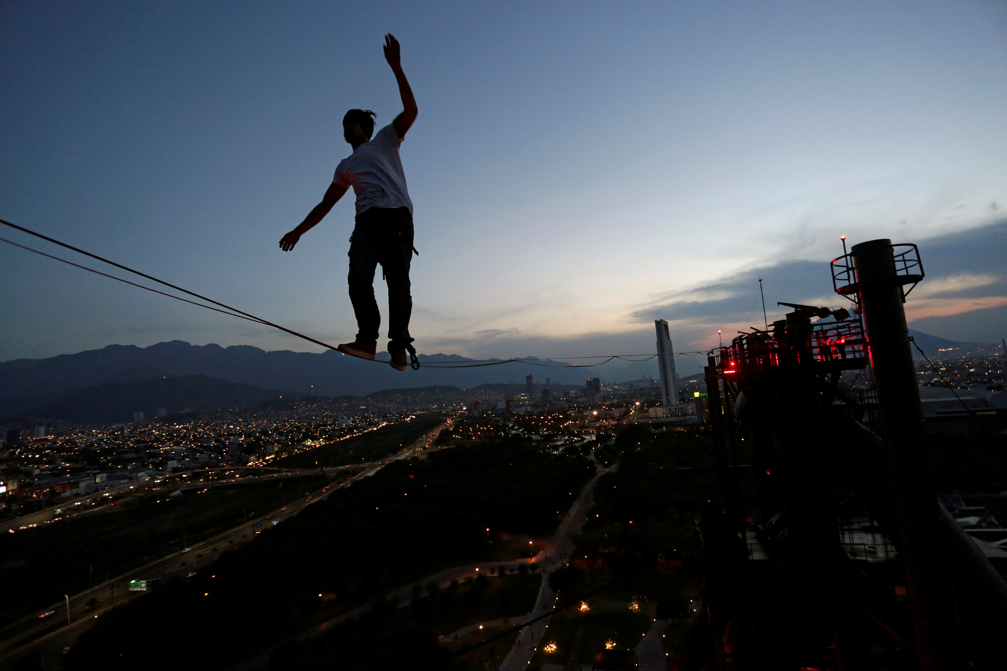 A slack-liner crosses a high wire between two chimneys of the structure housing former foundry Horno Alto No. 3, at Fundidora park in Monterrey, Mexico. PHOTO: REUTERS