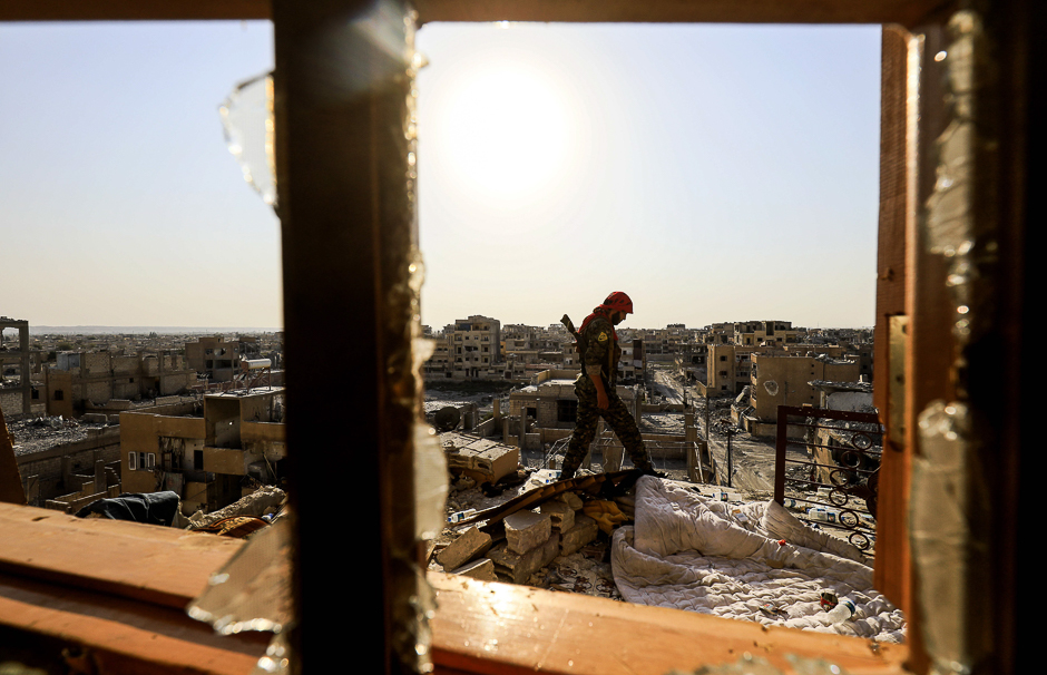 A member of the Syrian Democratic Forces (SDF), a US backed Kurdish-Arab alliance, walks on the roof of a building in the western al-Daraiya neighbourhood. PHOTO: AFP