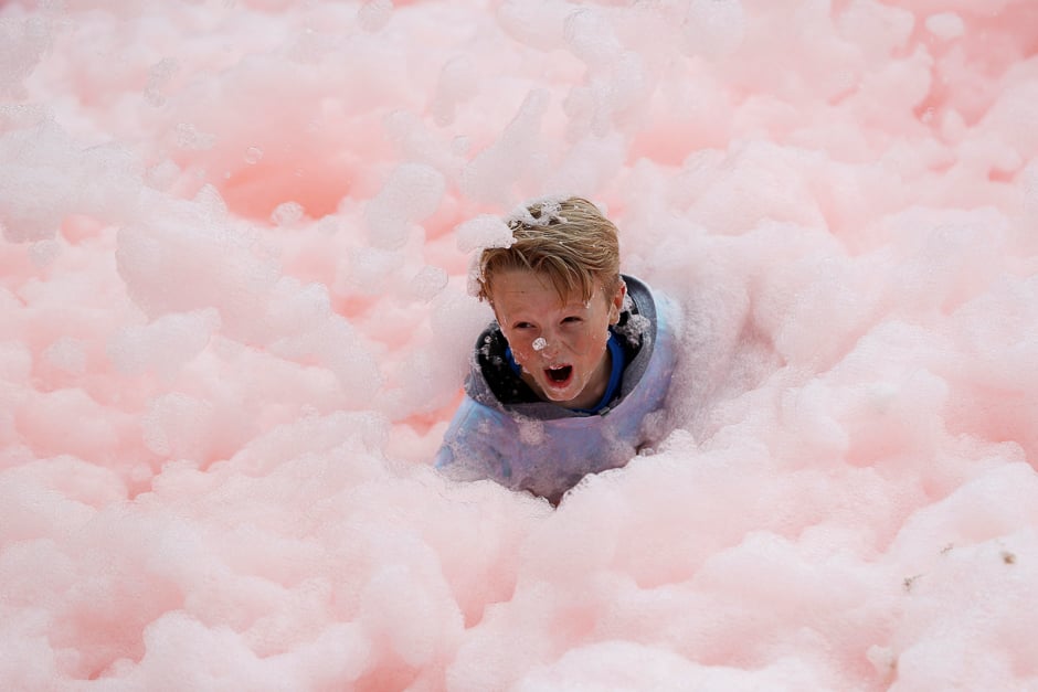 A boy falls during a charity bubble run in Leicester, Britain. PHOTO: REUTERS