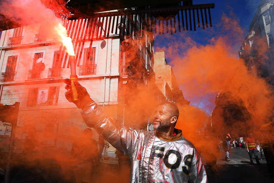 A worker of ArcelorMittal holds a flare during a protest called by several French unions against the labour law reform in Marseille, southern France. PHOTO: AFP