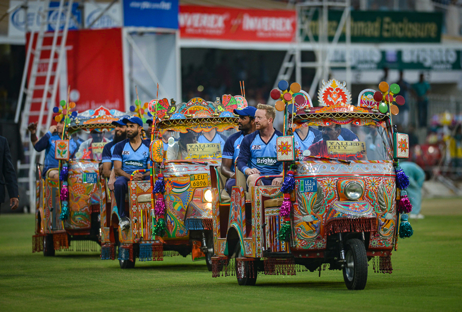 International World XI cricketers Ben Cutting (R), Morne Morkel (C) and Imran Tahir (L) sit in auto-rickshaws as they acknowledge the crowd at the main entrance of the Gaddafi Cricket Stadium in Lahore. PHOTO: AFP