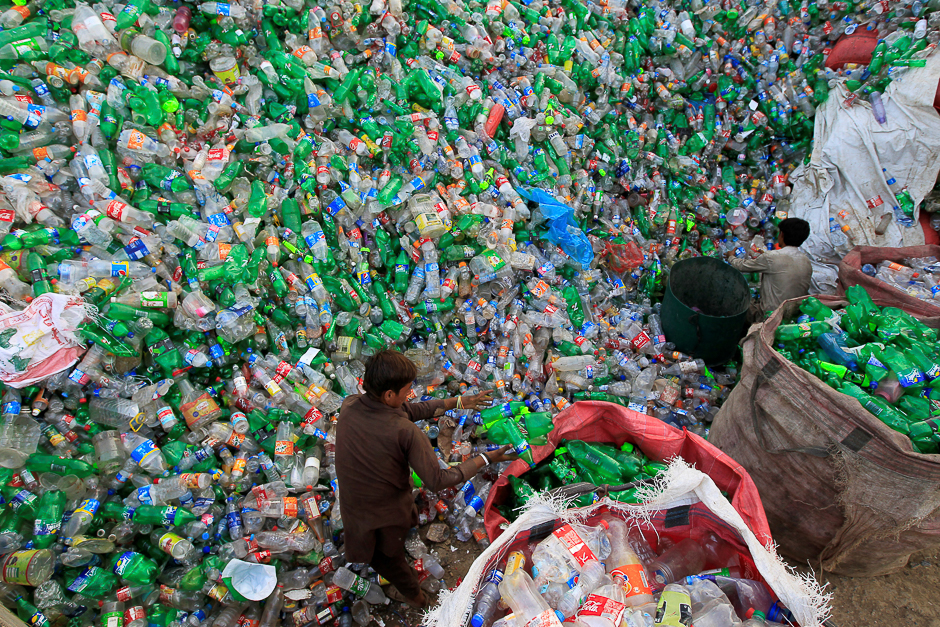 Workers sort bottles to throw them in a plastic bottle chipper at a recycling workshop in Islamabad. PHOTO: REUTERS