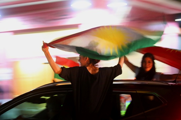 Syrian Kurds wave the Kurdish flag as they celebrate in the northeastern Syrian city of Qamishli. PHOTO: AFP