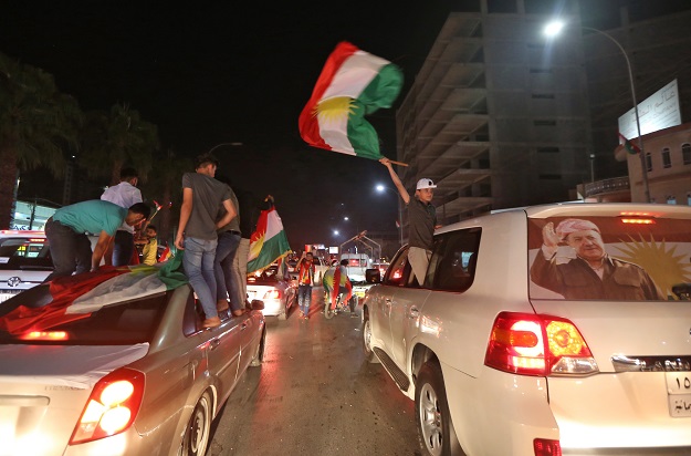 Iraqi Kurds wave the Kurdish flag as they celebrate in the streets of the northern city of Arbil. PHOTO: AFP