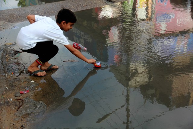 Children in the district play in the accumulated rainwater, which is a breeding ground for a variety of diseases. PHOTO: ATHAR KHAN/EXPRESS
