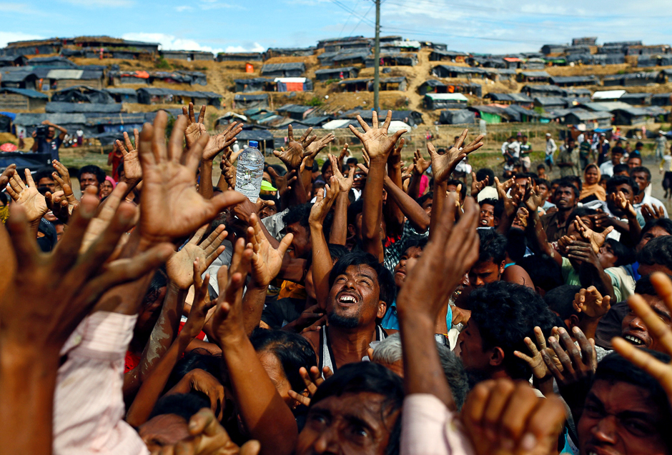 Rohingya refugees stretch their hands to receive aid distributed by local organisations at Balukhali makeshift refugee camp in Cox's Bazar, Bangladesh. PHOTO: REUTERS