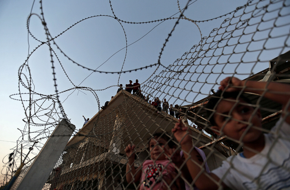 Palestinian children stand behind a fence as people wait for the return of their relatives from the annual Haj pilgrimage in Mecca, at Rafah border crossing in the southern Gaza Strip. PHOTO: REUTERS