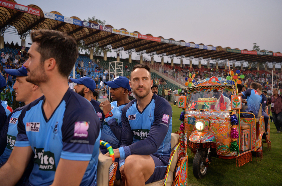 International World XI Faf du Plessis (C) sits with teammates in auto-rickshaws as they acknowledge the crowd at the main entrance of the Gaddafi Cricket Stadium in Lahore. PHOTO: AFP