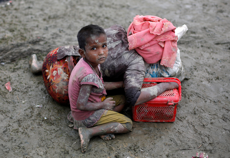 A Rohingya refugee girl sits next to her mother who rests after crossing the Bangladesh-Myanmar border, in Teknaf, Bangladesh. PHOTO: REUTERS