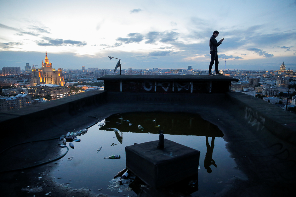 Sergii Rodionov takes a photograph on his mobile phone from a rooftop in Moscow, Russia. PHOTO: REUTERS