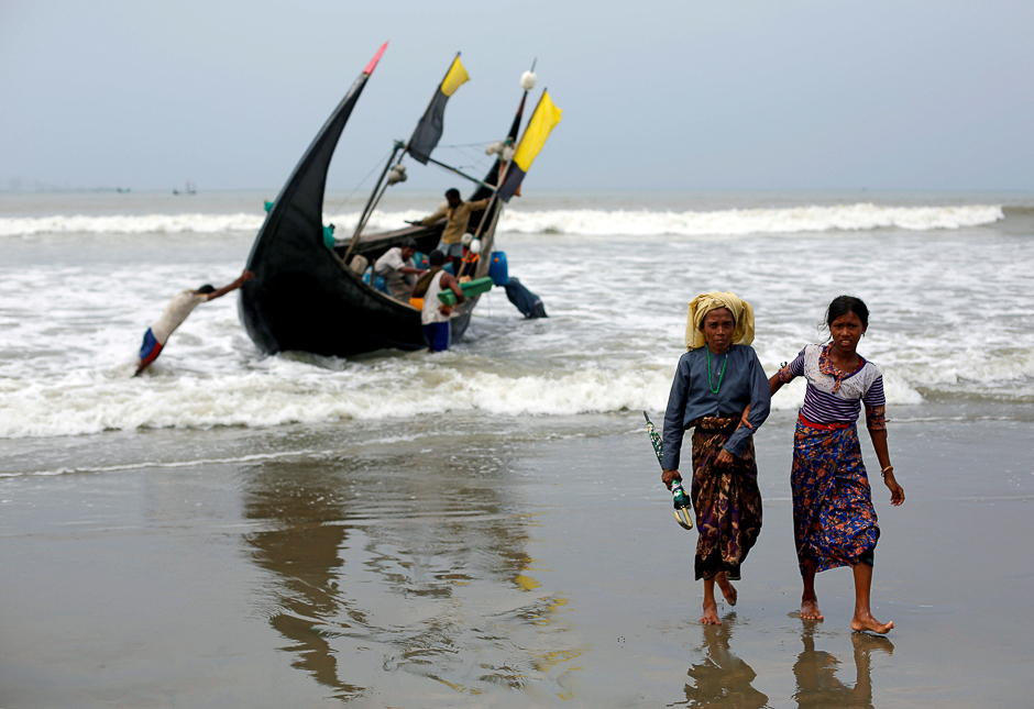 Rohingya refugees walk to the shore after crossing the Bangladesh-Myanmar border by boat through the Bay of Bengal in Teknaf, Bangladesh. PHOTO: REUTERS