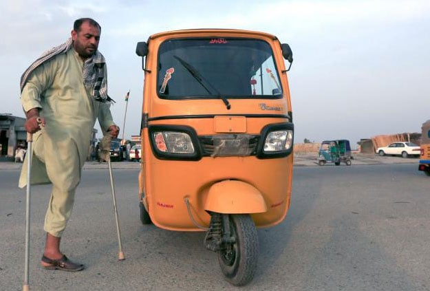 Bahader Khan, 33, a disabled Afghan National Army (ANA) soldier, walks next to his rickshaw car in Jalalabad province, Afghanistan. August 2, 2017. PHOTO: REUTERS