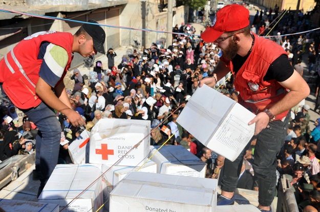 Members of the Syrian Red Crescent distribute humanitarian aid parcels to local residents in the northeastern city of Deir Ezzor. PHOTO: AFP