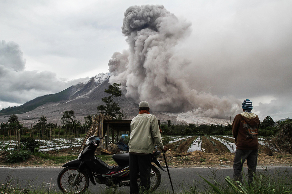 Indonesian villagers watch an eruption of Mount Sinabung volcano in Karo, North Sumatra. PHOTO: AFP