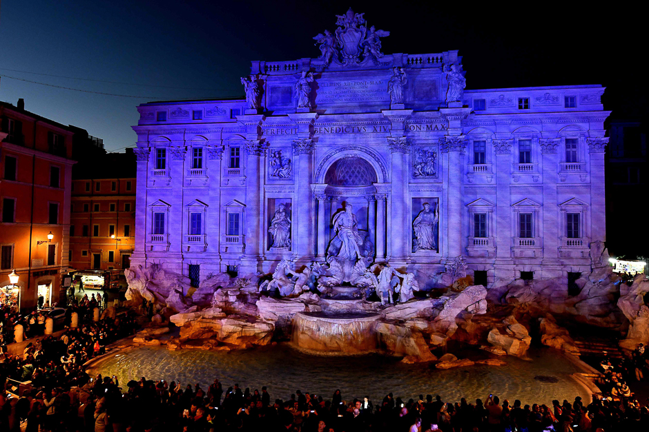 A picture shows Rome's Trevi fountain lit in blue. PHOTO: AFP