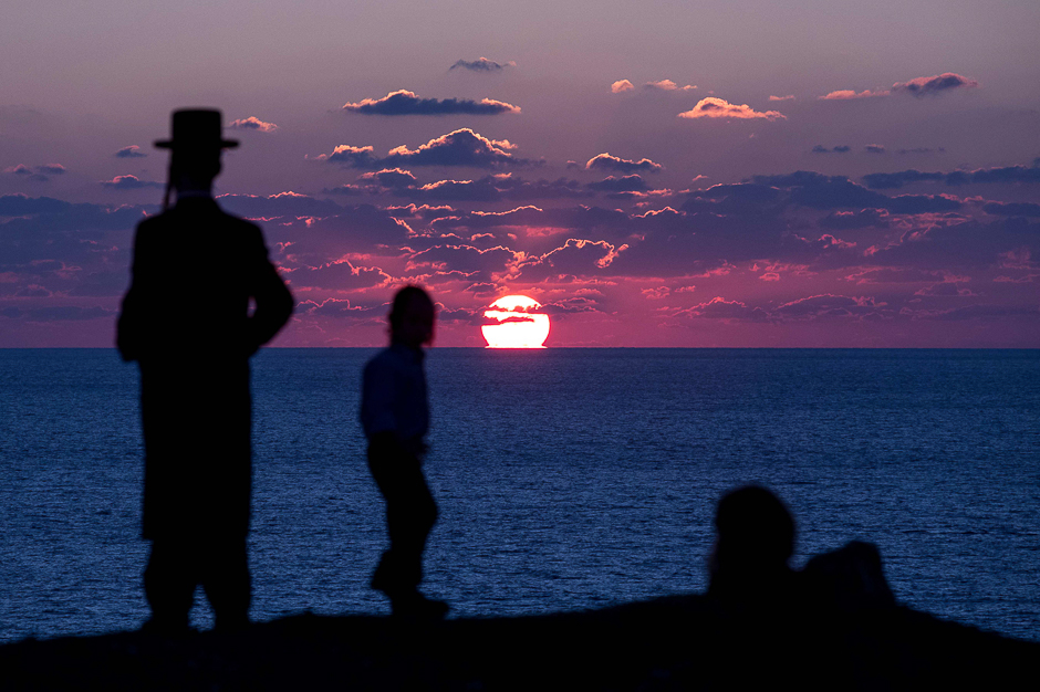 Ultra-Orthodox Jewish men pray along the Mediterranean Sea in the Israeli city of Herzliya, near Tel Aviv. PHOTO: AFP