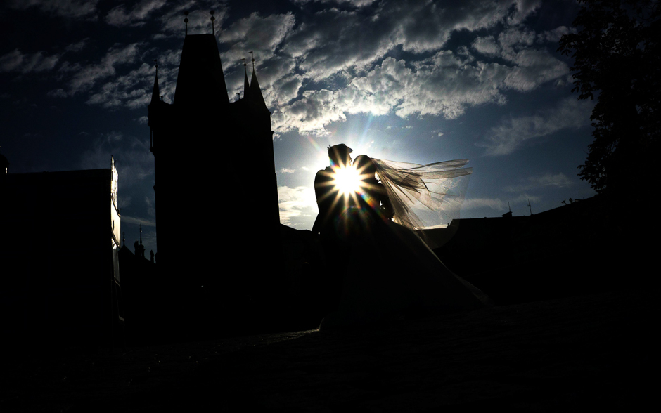 A just married couple from Asia pose for their photographer on the Charles Bridge on the early morning in Prague. PHOTO: AFP
