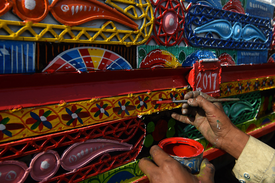 A Pakistani painter gives the finishing touches to the bodywork of a truck at a workshop in Peshawar. PHOTO: AFP
