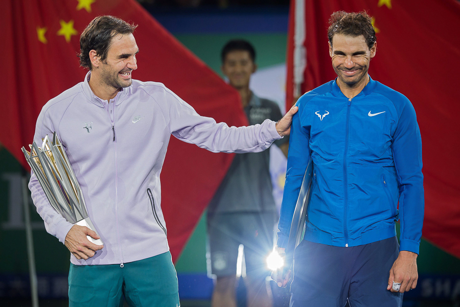 Winner Roger Federer of Switzerland (L) and second-placed Rafael Nadal of Spain react as they hold their trophies after the men's singles final match at the Shanghai Masters tennis tournament in Shanghai. PHOTO: AFP