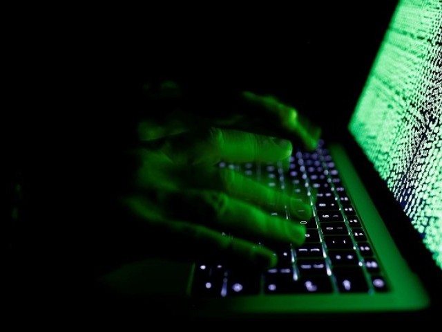 A man types on a computer keyboard in front of the displayed cyber code in this illustration picture taken on March 1,  2017.PHOTO: REUTERS