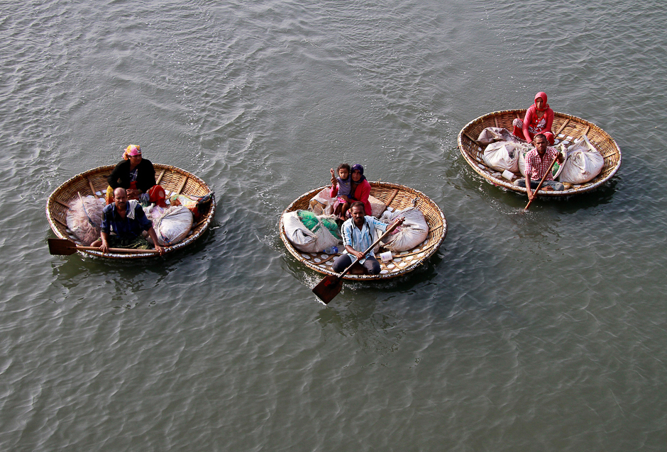 fishermen paddle their boats as they carry their family members in the waters of vembanad lake in kochi india photo reuters