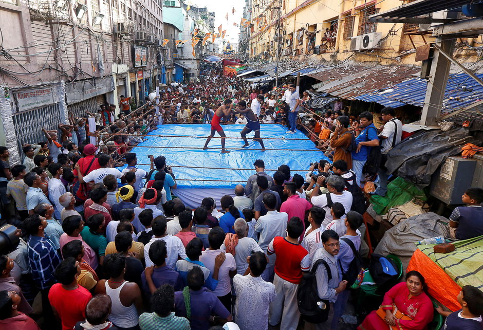 Wrestlers fight during an amateur wrestling match inside a makeshift ring installed on a road organised by local residents as part of Diwali, the festival of lights, celebrations in Kolkata, India. PHOTO: REUTERS