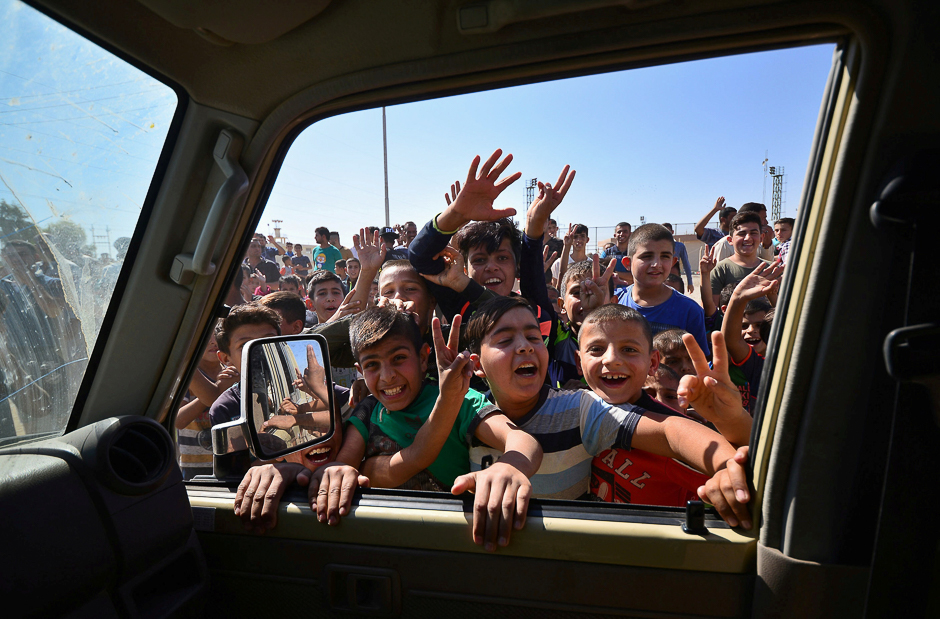 Iraqi boys gather on the road as they welcome Iraqi security forces members, who continue to advance in military vehicles in Kirkuk, Iraq. PHOTO: REUTERS