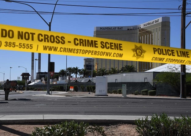 The damaged windows on the 32nd floor room that was used by the shooter in the Mandalay Hotel and the Route 91 festival venue (front) after a gunman killed more than 58 people and wounded more than 500 others when he opened fire on a country music festival in Las Vegas, Nevada on October 2, 2017. PHOTO: AFP