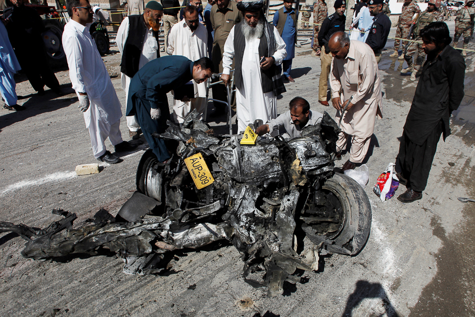 Security officials inspect a wreckage of a vehicle after a blast in Quetta, Pakistan. PHOTO: REUTERS