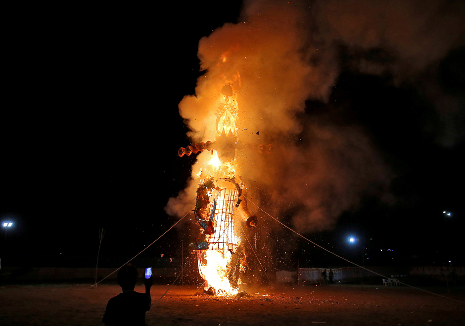 A man uses his mobile phone to take photographs of a burning effigy of demon King Ravana during Vijaya Dashmi, or Dussehra festival celebrations, in Ahmedabad, India. PHOTO: REUTERS