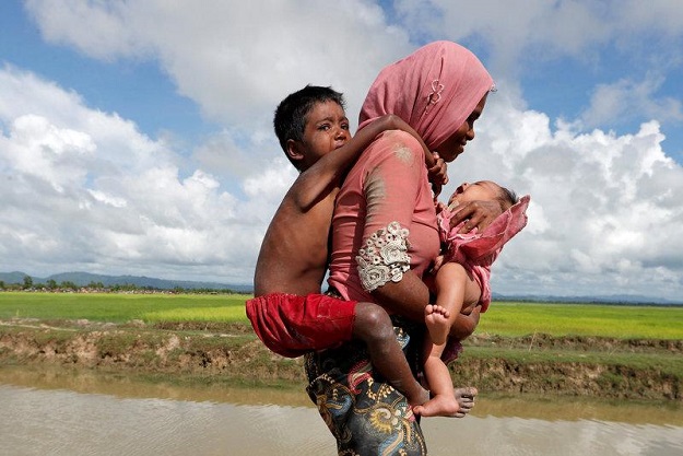 Rohingya refugees walk in a rice field after crossing the border in Palang Khali, Bangladesh October 9, 2017. PHOTO: REUTERS