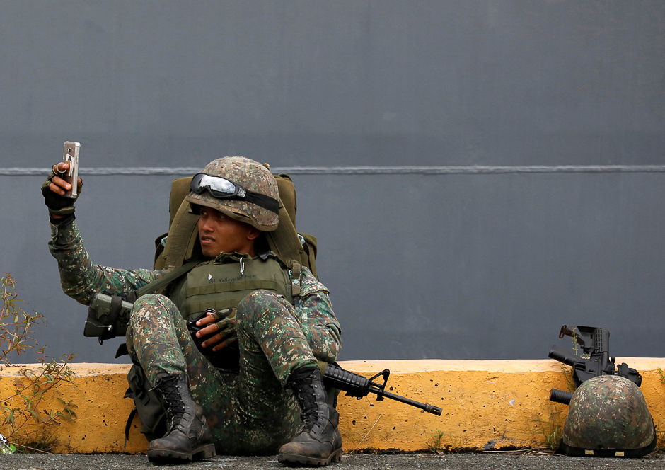 A Philippine marine soldier takes a selfie with his phone during their arrival from Marawi at port area in metro Manila, Philippines. PHOTO: REUTERS