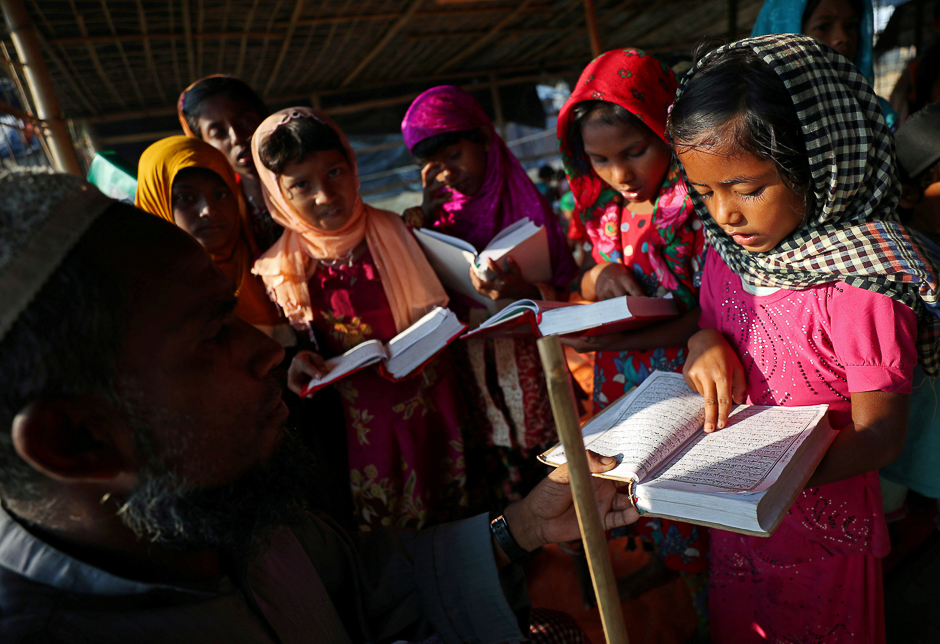 A Rohingya refugee girl reads the Quran to her teacher during a Quran reading lesson at a mosque in Palong Khali refugee camp near Cox's Bazar, Bangladesh. PHOTO: REUTERS