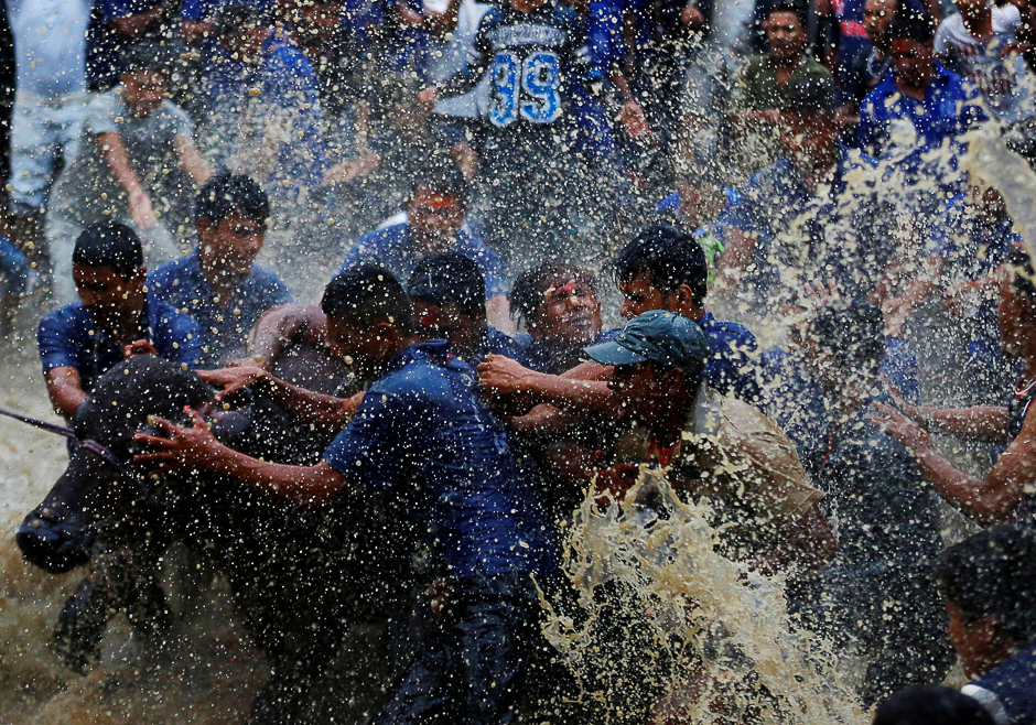 People splash water on a buffalo to prepare it for sacrifice during 