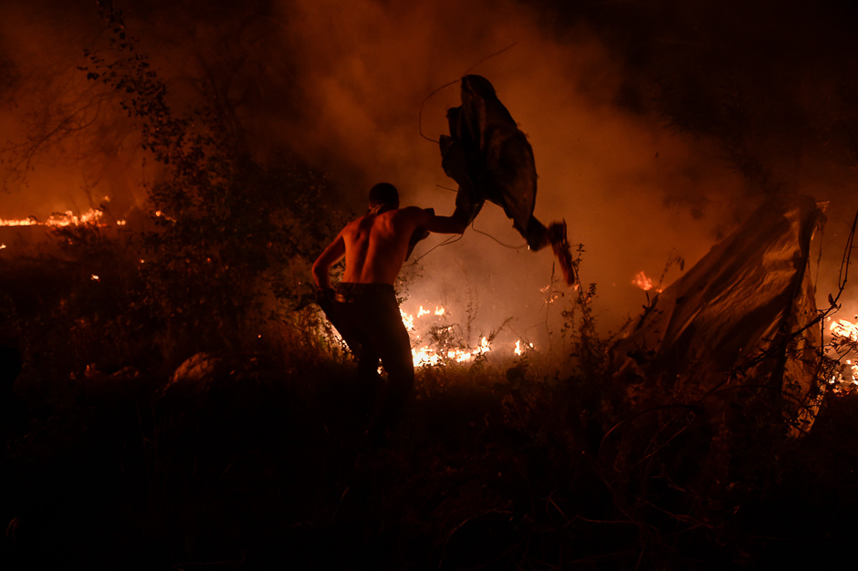 A man attempts to subdue wildfire flames in Vigo, northwestern Spain. PHOTO: AFP