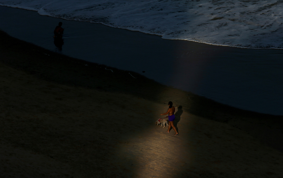 A woman walks with her dog on the Boa Viagem beach in Recife, northeastern Brazil. PHOTO: REUTERS
